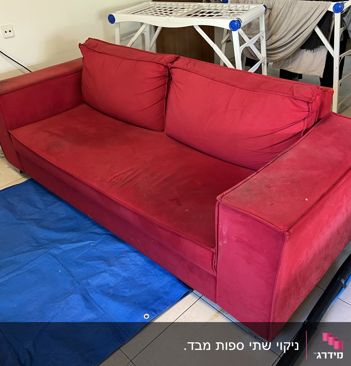 ספה אדומה עם כתמים על יריעת פלסטיק כחולה